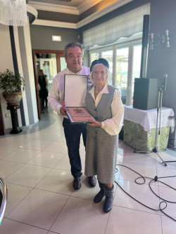 El alcalde de Noja, Miguel Ángel Ruiz Lavín, entregó a la vecina centenaria una placa de maderacon el portón de entrada del Palacio de Albaicín serigrafiado