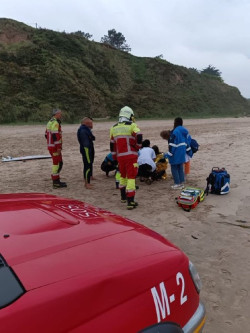 Equipos de emergencias atienden a un surfista con el hombro dislocado en la playa del Rosal